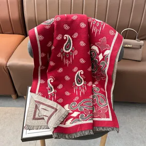 Dettaglio dello scialle jacquard rosso paisley con frange su una sedia