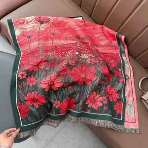 Châle d'hiver en tricot avec motifs floraux rouge et vert et franges sur canapé
