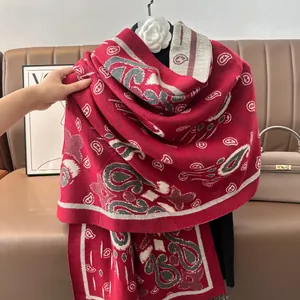 Dettaglio dello scialle bohémien rosso con motivi jacquard paisley e bordi con frange
