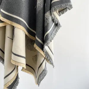 Detail of ginkgo leaf jacquard knit shawl with thick fringe edges and soft texture