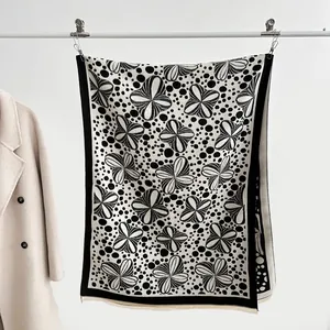 Close-up of black and white polka dot jacquard scarf with delicate short fringe details