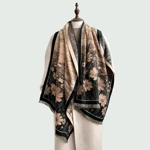 Vue détaillée du tissage jacquard marguerites et des franges sur le châle chaud