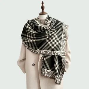 Detail of plaid scarf with leopard print trim and soft fringes over a beige wool coat