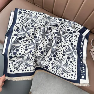 Detail of navy and cream floral pashmina scarf with soft fringes on leather seat
