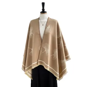 Knitted shawl cape with ginkgo leaf pattern and tassels on female mannequin