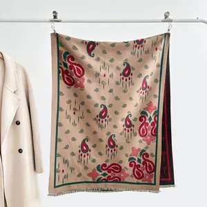 Dettaglio di motivi paisley boho e frange su uno scialle jacquard invernale