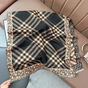 Detail of leopard print and geometric plaid scarf with delicate fringed edges