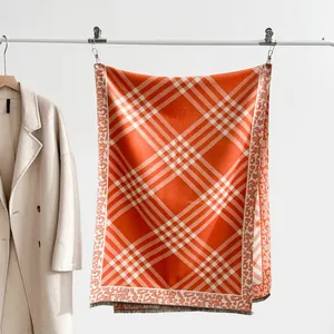 Detail view of plaid scarf featuring leopard print edges and grey fringe accents