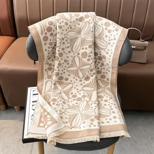 Detail of beige jacquard floral shawl with tassels draped on a modern dining chair