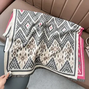 Gros plan sur l'écharpe en maille jacquard avec motif géométrique et bords à franges