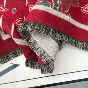 Dettaglio macro del tessuto jacquard rosso scuro con eleganti bordi a frange grigi e bianchi