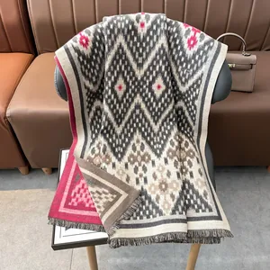 Gros plan d'un châle pashmina épais à motifs géométriques et bordures frangées