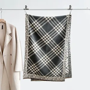 Detail of autumn plaid jacquard scarf with leopard print borders and fringe tassels