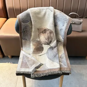 Thick jacquard shawl with realistic leaf patterns and fringe edges on a chair