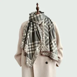 Fashionable autumn grey leopard plaid scarf with soft fringe on a beige wool coat