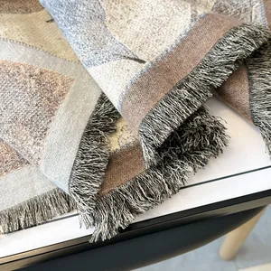 Detail view of woven blanket with vintage abstract patterns and thick fringe edges