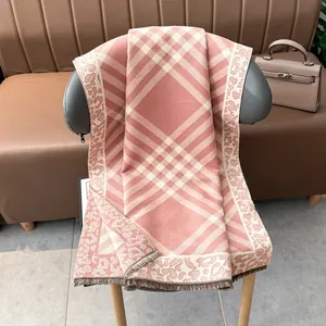 Detail of plaid scarf with leopard print edge and fringe on a luxury chair