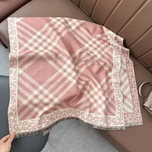 Detail of pink plaid scarf featuring leopard print jacquard edges and fine fringe trim
