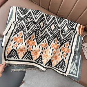 Détail d'un châle d'hiver épais avec motifs géométriques et bords à franges