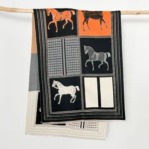 Scialle in cashmere con motivo equestre e blocchi di colore arancione e nero su gruccia in legno