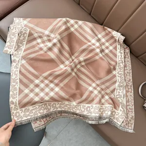 Close-up of brown and beige plaid scarf with leopard print trim and fringe details