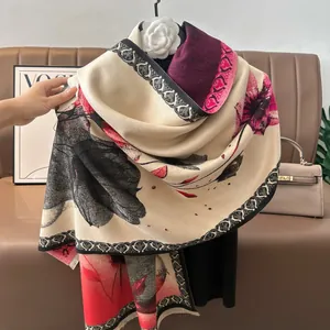 Detailed close-up of cashmere-like floral scarf with tassels and chain borders
