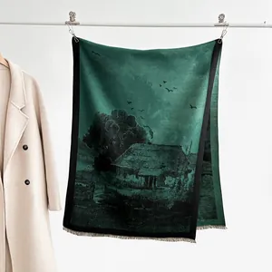 Detail of dark green cashmere-style scarf featuring artistic landscape print and fringe trim