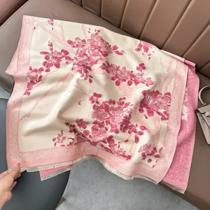 Detalle de flores de ciruelo rosas en bufanda de cachemira con flecos y borde decorativo