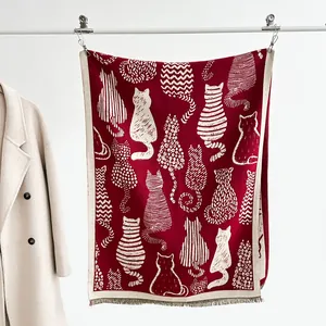 Detail of burgundy cashmere shawl with white cat silhouettes and decorative fringes