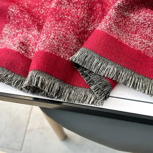 Macro view of red knit scarf featuring shimmering metallic threads and dense fringe trim