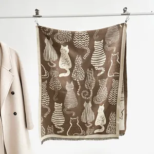 Detail of artistic cat silhouette print and soft fringe on brown pashmina shawl