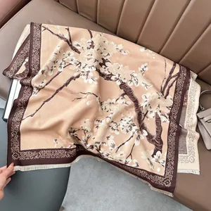 Detalle de bufanda de cachemira beige con elegante estampado floral de ciruelo y bordes de flecos