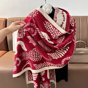 Elegant red and cream cat print cashmere feel scarf with fringe on a leather sofa