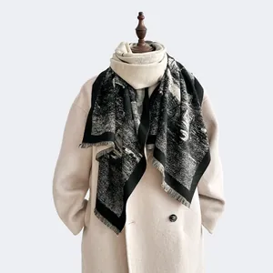 Close-up of thick cashmere-like scarf with black and white ink pattern and long tassels