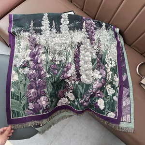 Floral print cashmere-like winter scarf with lavender patterns and tassels on leather sofa