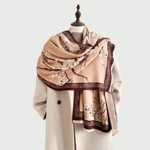 Detalle de chal de cachemira de invierno con flores de ciruelo vintage y flecos suaves