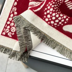 Detail of red and white patterned knit scarf featuring soft fringe edges and texture