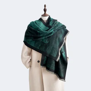 Detail of forest ink painting pashmina scarf with fine fringe tassels on a beige coat