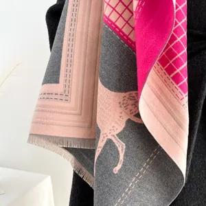 Dettaglio della sciarpa con motivo a cavallo, design color-block e morbide frange