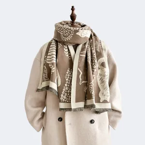 Detail of winter scarf with brown and beige forest jacquard patterns and fine tassels