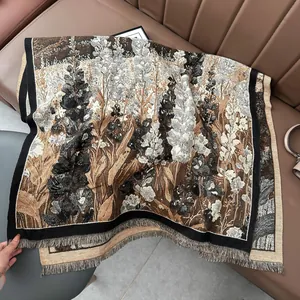 Detail of floral jacquard texture and fringed edges on a warm cashmere-like scarf