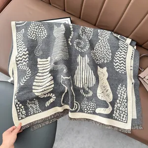 Detailed view of cat pattern knit texture and fringe edge on soft grey cashmere-like scarf