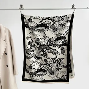 Detail of cashmere-like scarf showing classic black and white pine and cloud patterns
