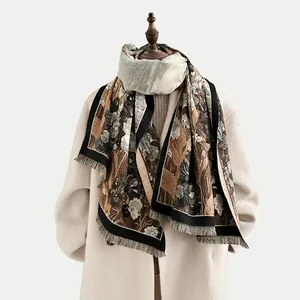 Detail of floral cashmere-like scarf with fringe edges draped over a beige winter coat