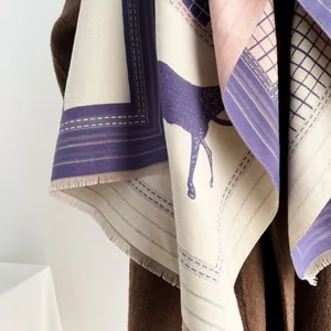 Dettaglio dello scialle in cashmere con stampa equina, trama scozzese viola e frange