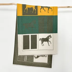 Dettaglio della sciarpa in cashmere con motivi equestri e blocchi di colori vivaci