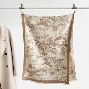 Detail of elegant beige scarf with traditional patterns hung by a cashmere coat