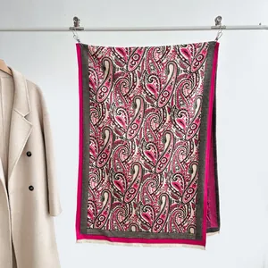 Detail of rose pink and beige paisley pattern jacquard scarf with soft fringe edges
