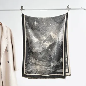 Close-up of retro mountain landscape pattern and fringe detail on cashmere shawl