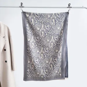 Detail of navy paisley jacquard scarf with fringe and subtle stripe border